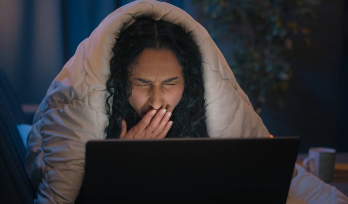 Tired Hispanic girl exhausted sleepy woman fatigued Indian Arabian female at night evening home couch sofa under blanket cover duvet working with laptop watching movie computer addict yawn need sleep. High quality 4k footage