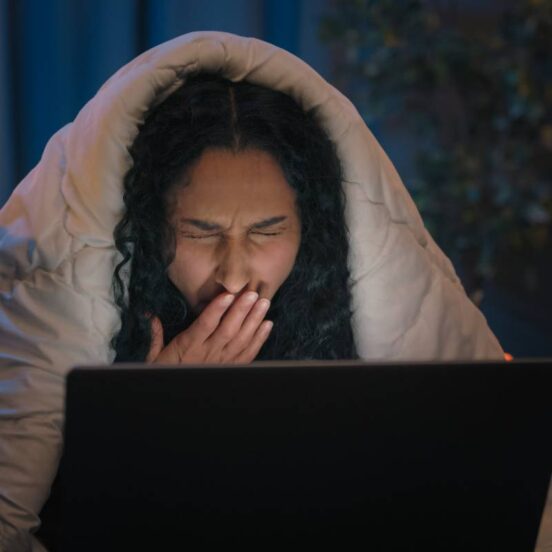 Tired Hispanic girl exhausted sleepy woman fatigued Indian Arabian female at night evening home couch sofa under blanket cover duvet working with laptop watching movie computer addict yawn need sleep. High quality 4k footage